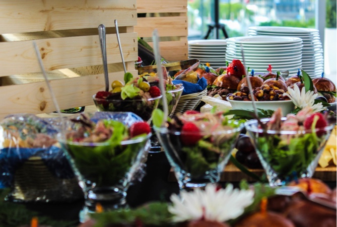 Buffet de cocktail dinatoire raffiné avec verrines colorées et mini-burgers gourmands.